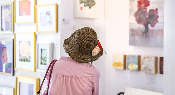 a woman contemplates local art at a gallery in Hendersonville, NC
